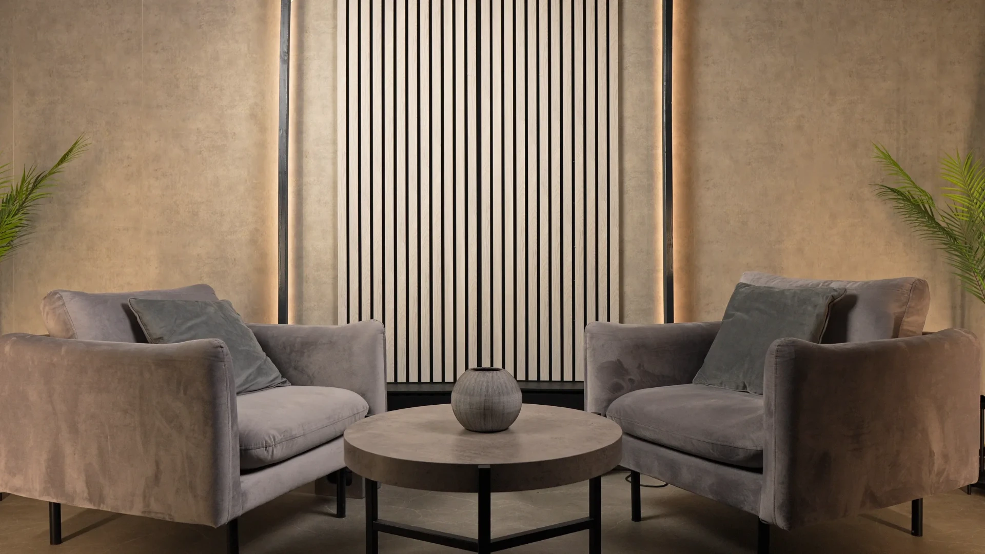 Studio d'entretien : deux fauteuils face à face, panneau acoustique en bois et lumière tamisée